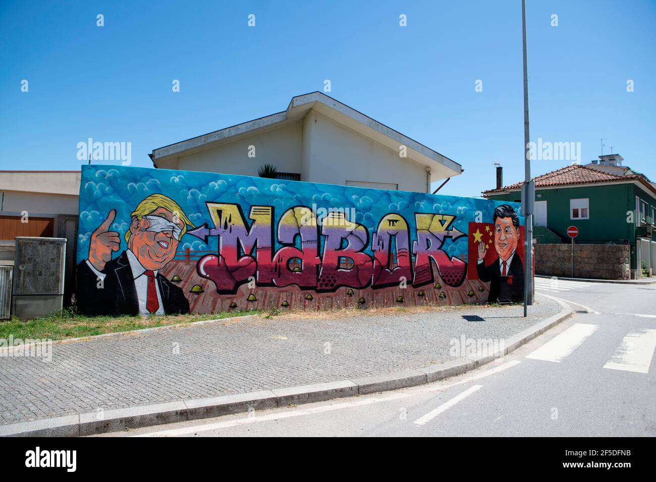 A graffiti by street artist, Mabor portraying former USA president Donald Trump wearing a surgical mask covering his eyes and Chinese president Xi Jinping waving. Stock Photo