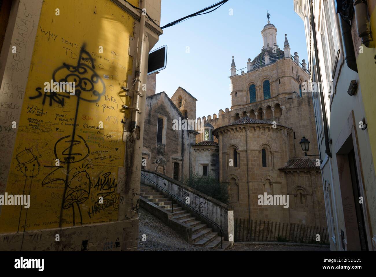 Disfiguring graffiti on a yellow wall near the Old Cathedral of Coimbra ( Sé Velha de Coimbra) . Portugal. Stock Photo