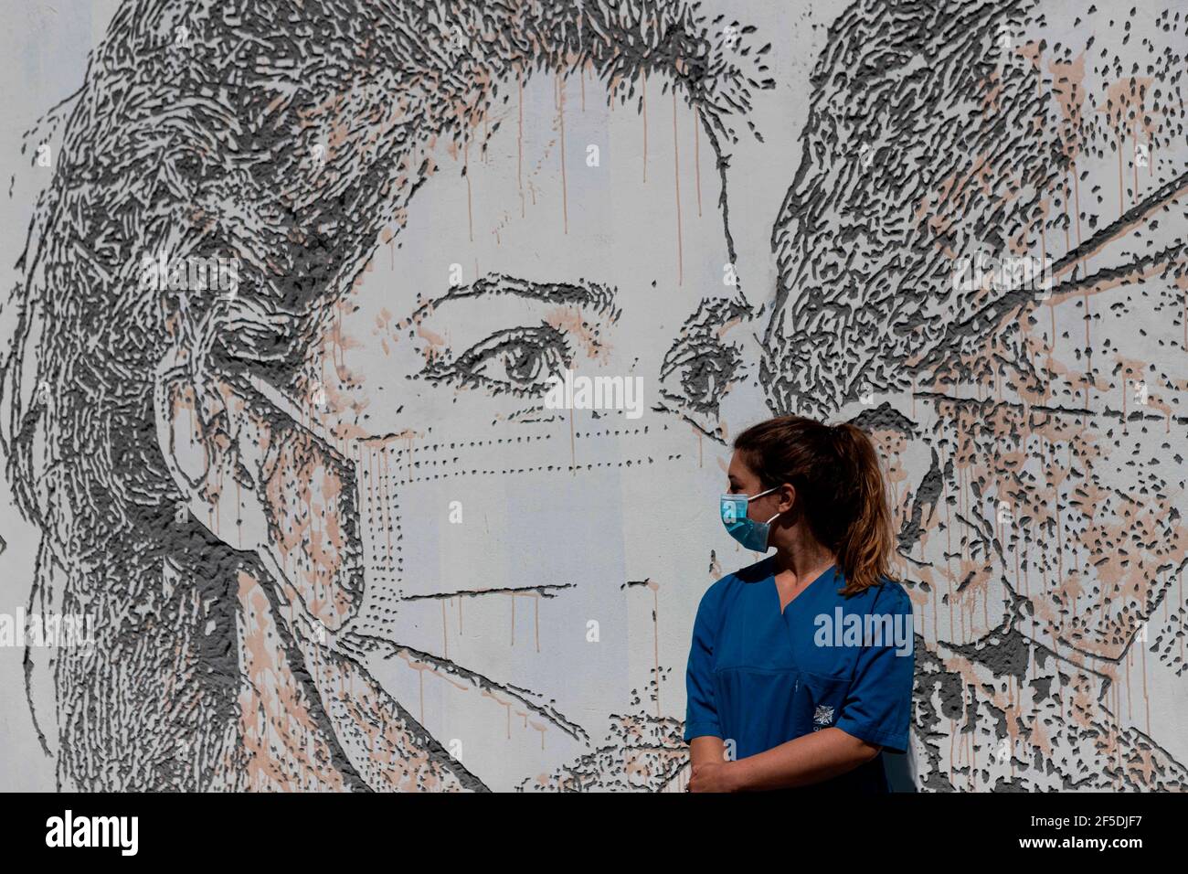June 19, 2020, Porto, Portugal: PatrÃcia Botelho, nurse, poses in front of her portrait by Vhils, a famous Portuguese street artist, who sculpted the mural â€œLinha da Frente: Projeto Scratching the Surfaceâ€, meaning ''Frontline: Project Scratching the Surface'' paying tribute to all the hospital staff in the frontline. Not only doctors and nurses but also janitors and receptionists..The street murals are located at the Hospital de SÃ£o JoÃ£o, one of the biggest hospitals in Portugal and the main one to take care of COVID-19 patients in the northern part of the country. (Credit Image: © Ter Stock Photo