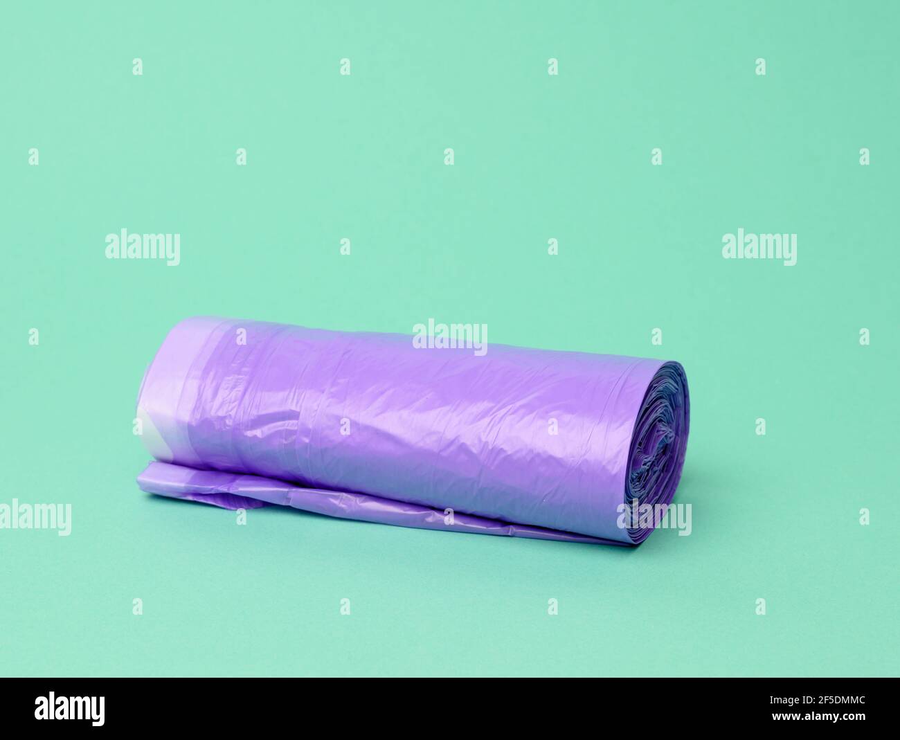 https://c8.alamy.com/comp/2F5DMMC/skein-of-purple-plastic-trash-bags-with-strings-on-a-green-background-close-up-2F5DMMC.jpg