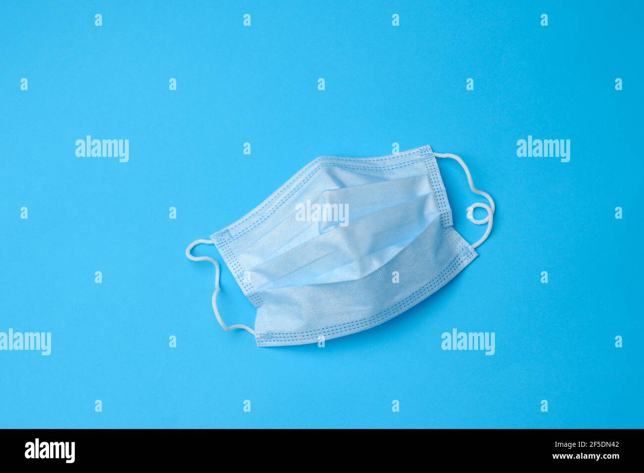 blue disposable medical mask on a blue background, personal protective ...