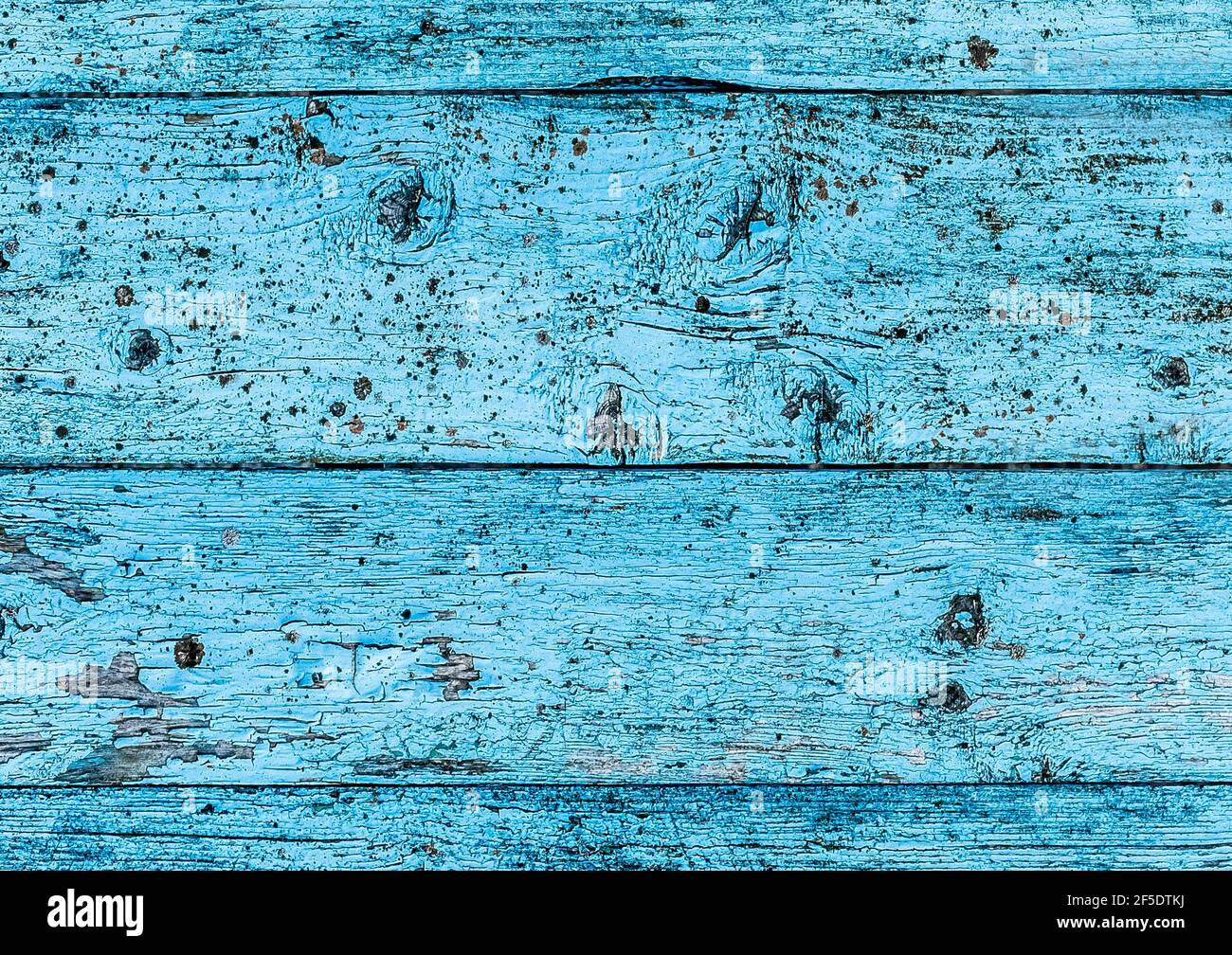 Texture of old wooden fence with blue peeling paint, abstract plank background. Stock Photo