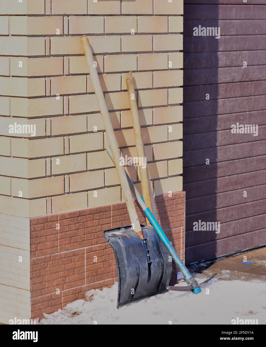 shovel and pickaxe against a brick wall Stock Photo