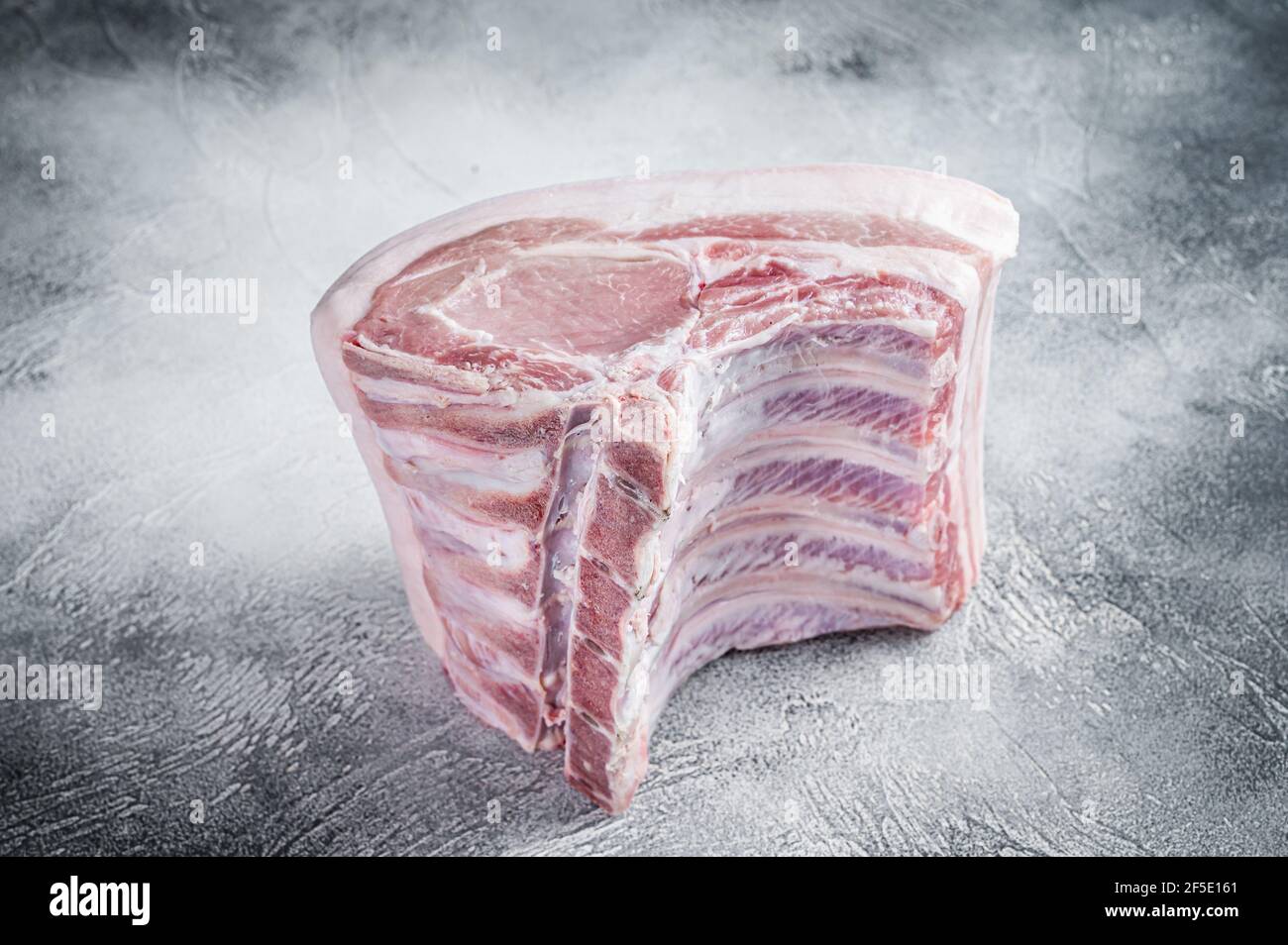 Raw whole rack of pork loin with ribs on kitchen table. White ...