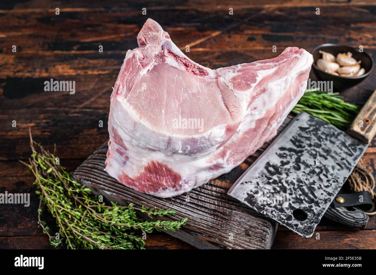 Raw rack of pork loin chops with ribs on a butcher board with meat ...