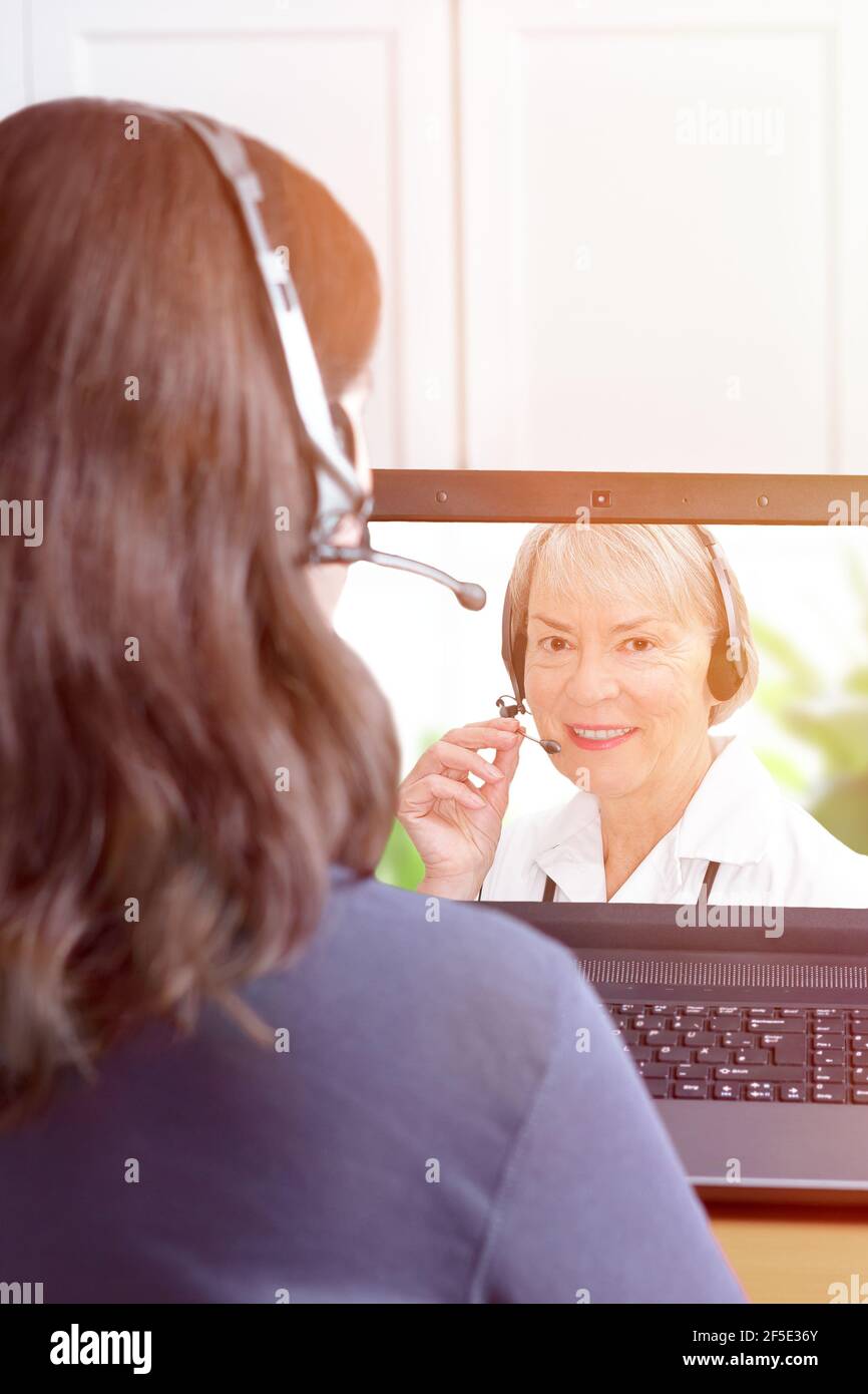 Telehealth or telemedicine concept: woman with headset making a video call with her doctor. Stock Photo