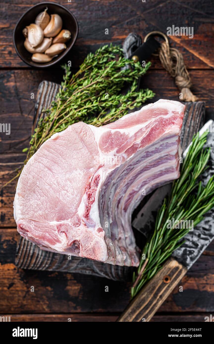 Raw rack of pork loin chops with ribs on a butcher board with meat ...