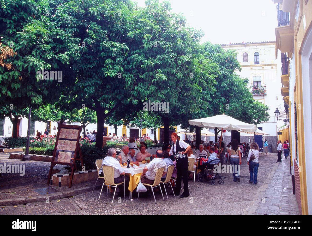 People sitting on restaurant terrace. Barrio de Santa Cruz, Sevilla, Andalucia, Spain. Stock Photo