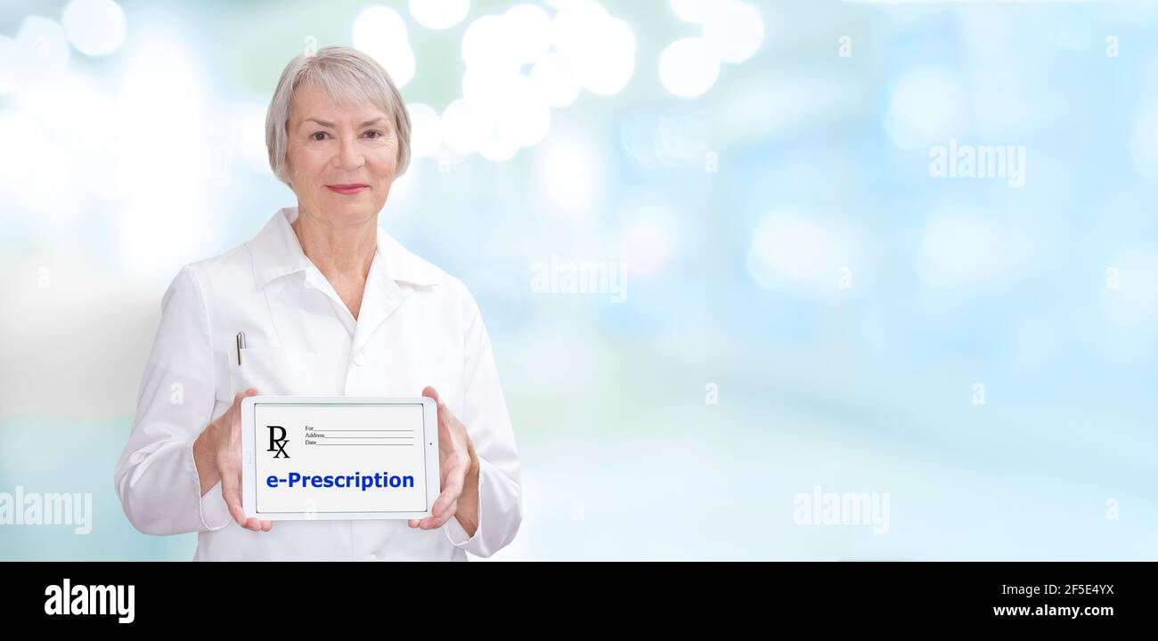 Smiling pharmacist showing a tablet computer with the text: e-prescription, meaning electronic prescription. Stock Photo
