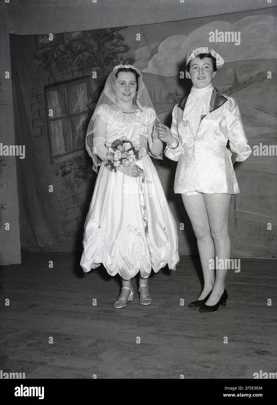 1956, historical, standing on a stage, two young ladies in the costumes of their characters from the play, Jack & the Beanstalk, England, UK. An ancient folk story, it was first published as an English fairy tale, 'The Story of Jack Spriggins and the Enchanted Bean' in 1734 and then in 1807 in 'The History of Jack and the Bean-Stalk' by Benjamin Tabert. Fairy tales are ancient folklore, featuriing mythical creatures; elves, fairies, talking animals, witches and giants in magical stories that are far-fetched and not true and indeed could not possiblly be true. Stock Photo