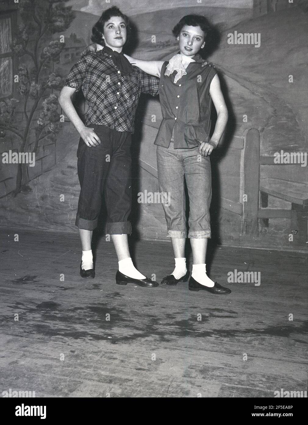1956, historical, standing on a stage, two young ladies in the costumes of their characters from the play, Jack & the Beanstalk, England, UK. An ancient folk story, it was first published as an English fairy tale, 'The Story of Jack Spriggins and the Enchanted Bean' in 1734 and then in 1807 in 'The History of Jack and the Bean-Stalk' by Benjamin Tabert.  Fairy tales are ancient folklore, featuriing mythical creatures; elves, fairies, talking animals, witches and giants in magical stories that are far-fetched and not true and indeed could not possiblly be true. Stock Photo