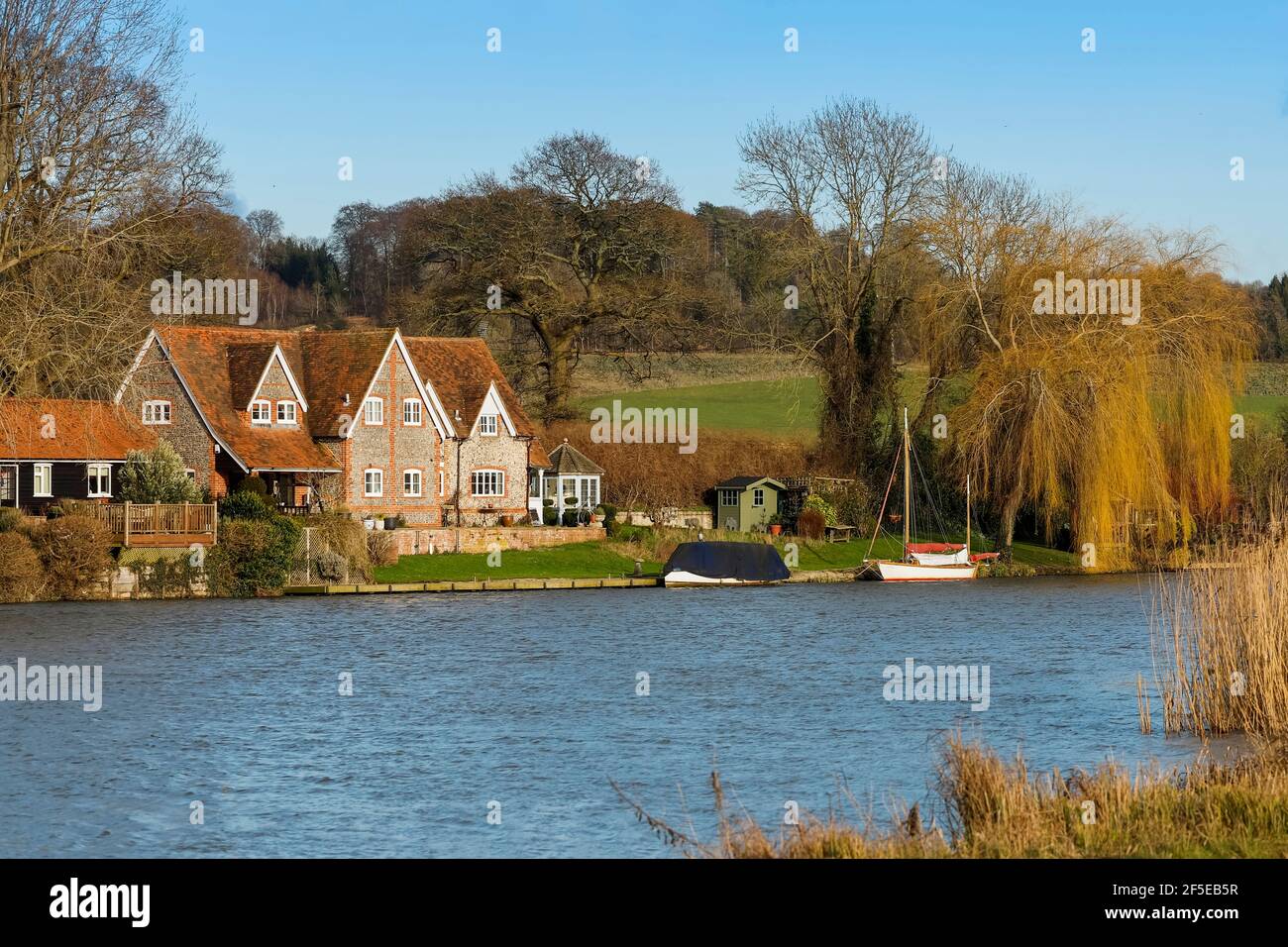 Typical gable fronted brick & flint house and willow tree by the River