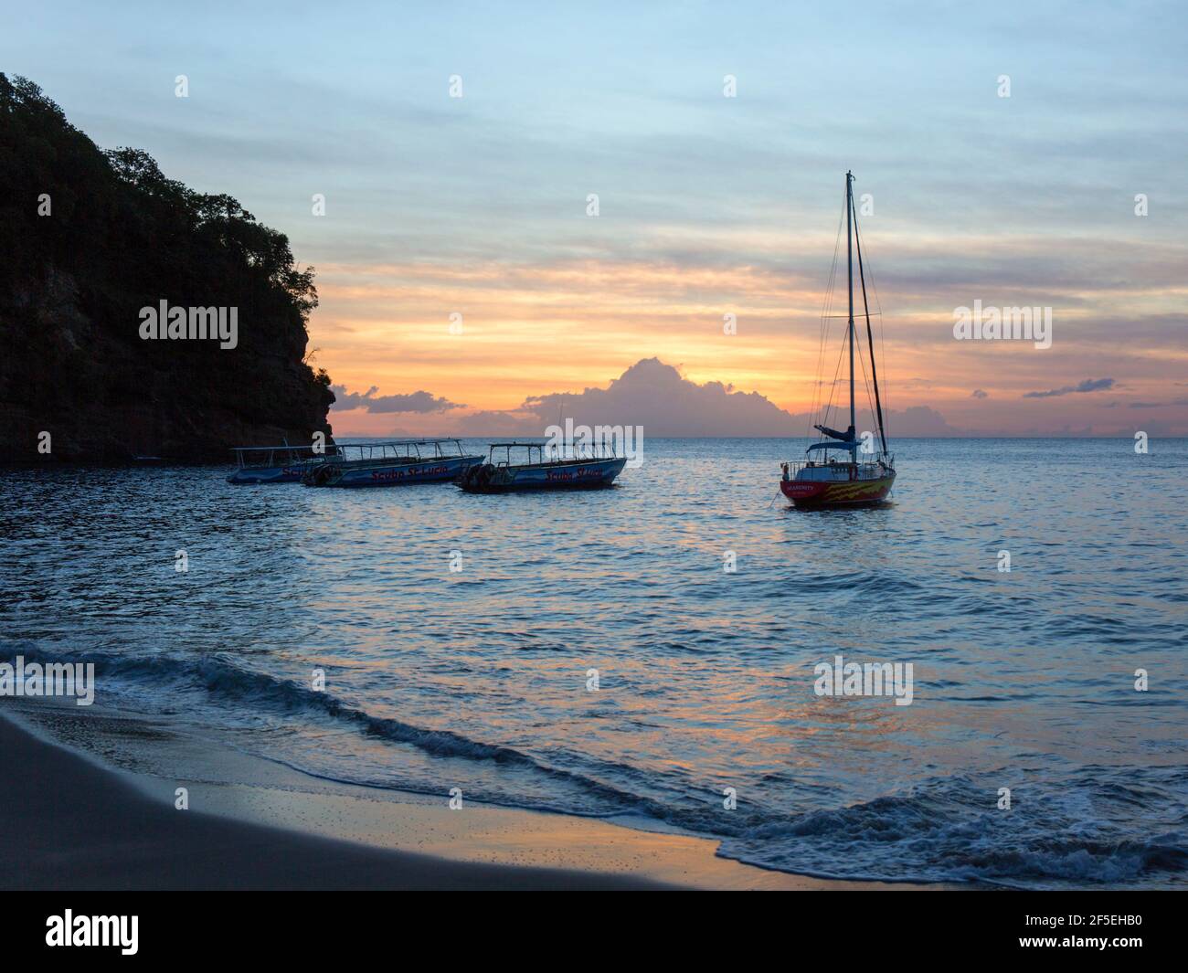Soufriere, St Lucia. View from beach across the Caribbean Sea at sunset, boats anchored offshore, Anse Chastanet. Stock Photo