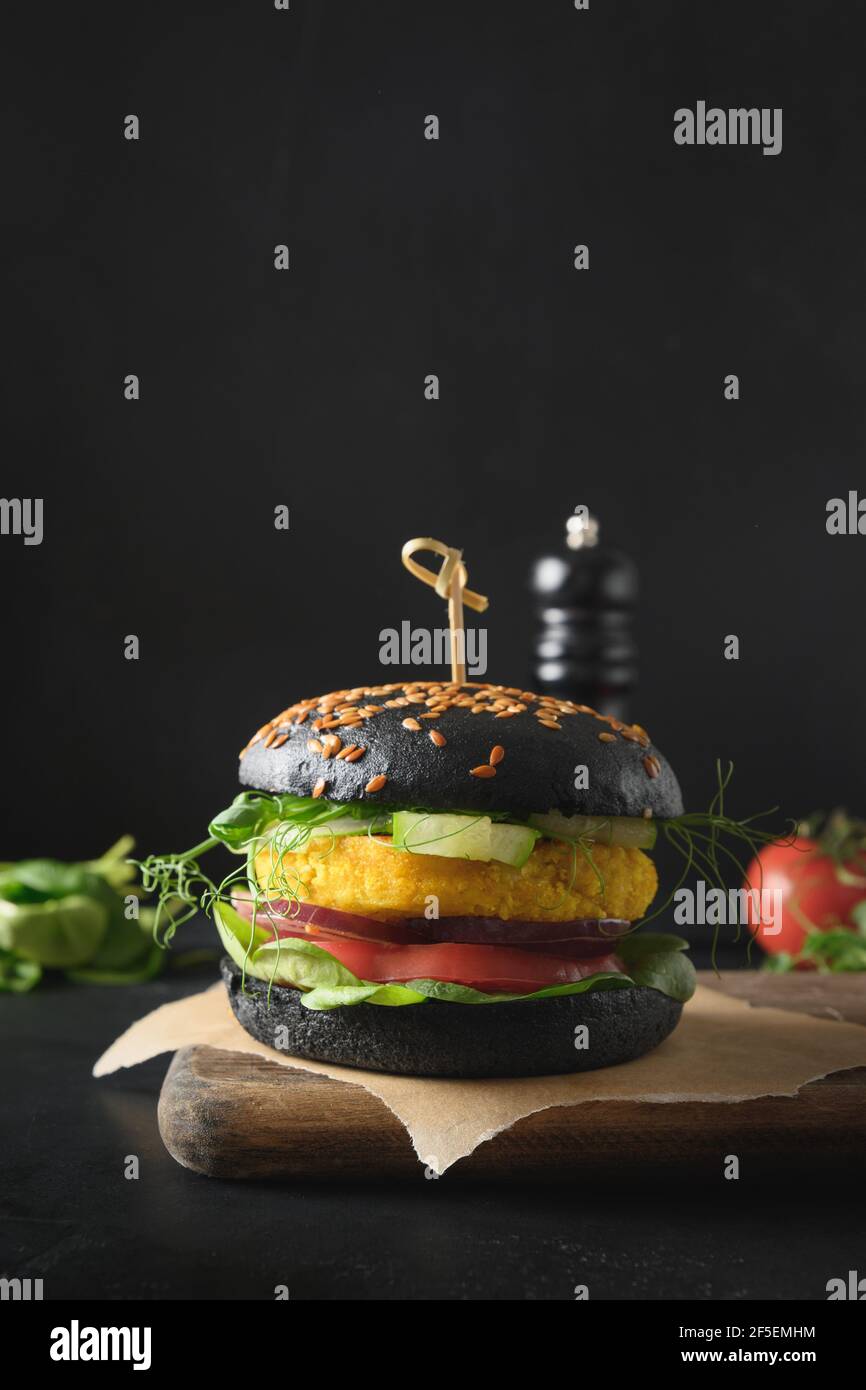 Trendy Vegan Burger of black charcoal buns, vegetables, cabbage and