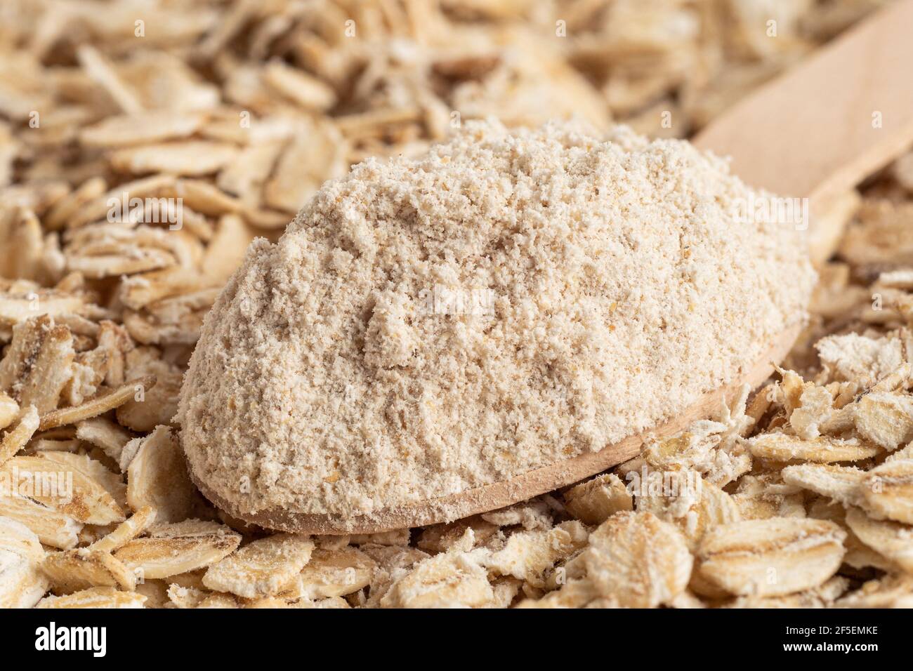 Spoonful of oat flour on top of uncooked porridge oats. Blur. Background. Stock Photo