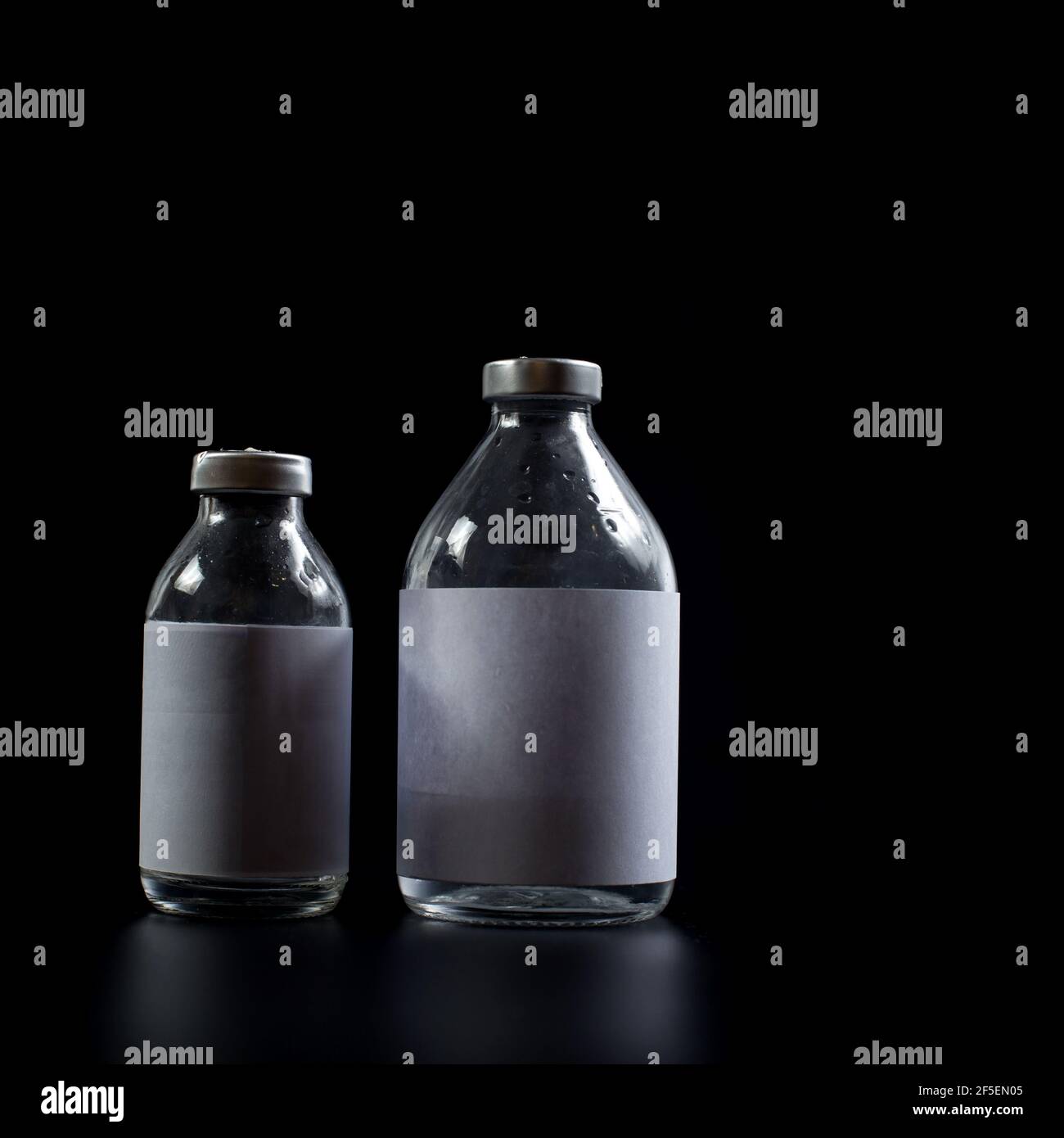 Medical glass containers with no logo isolated on black. Stock Photo