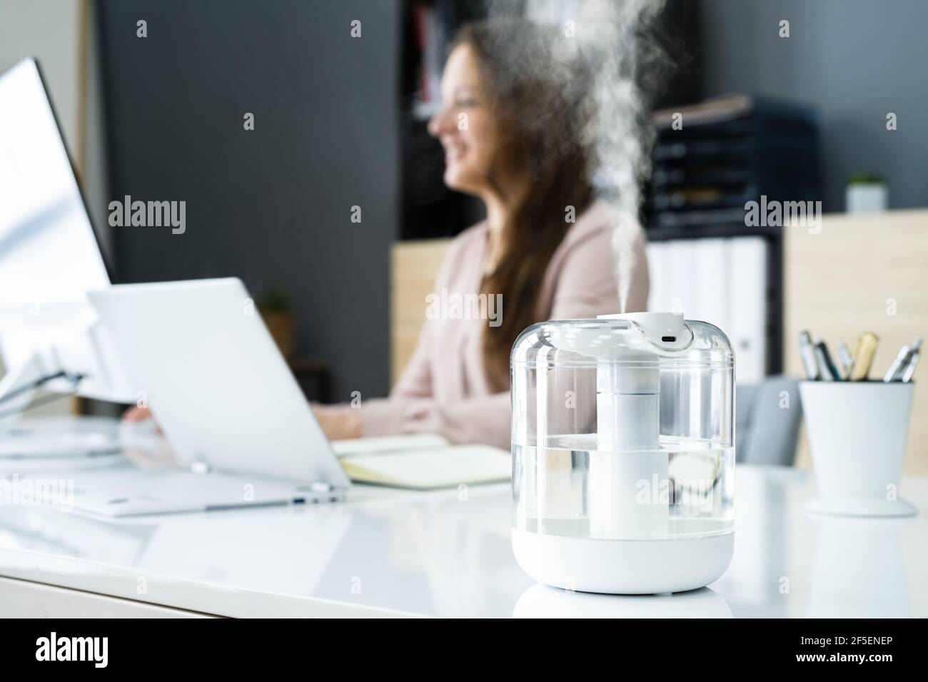 Air Humidifier Device At Office Desk Near Woman Working Stock Photo - Alamy