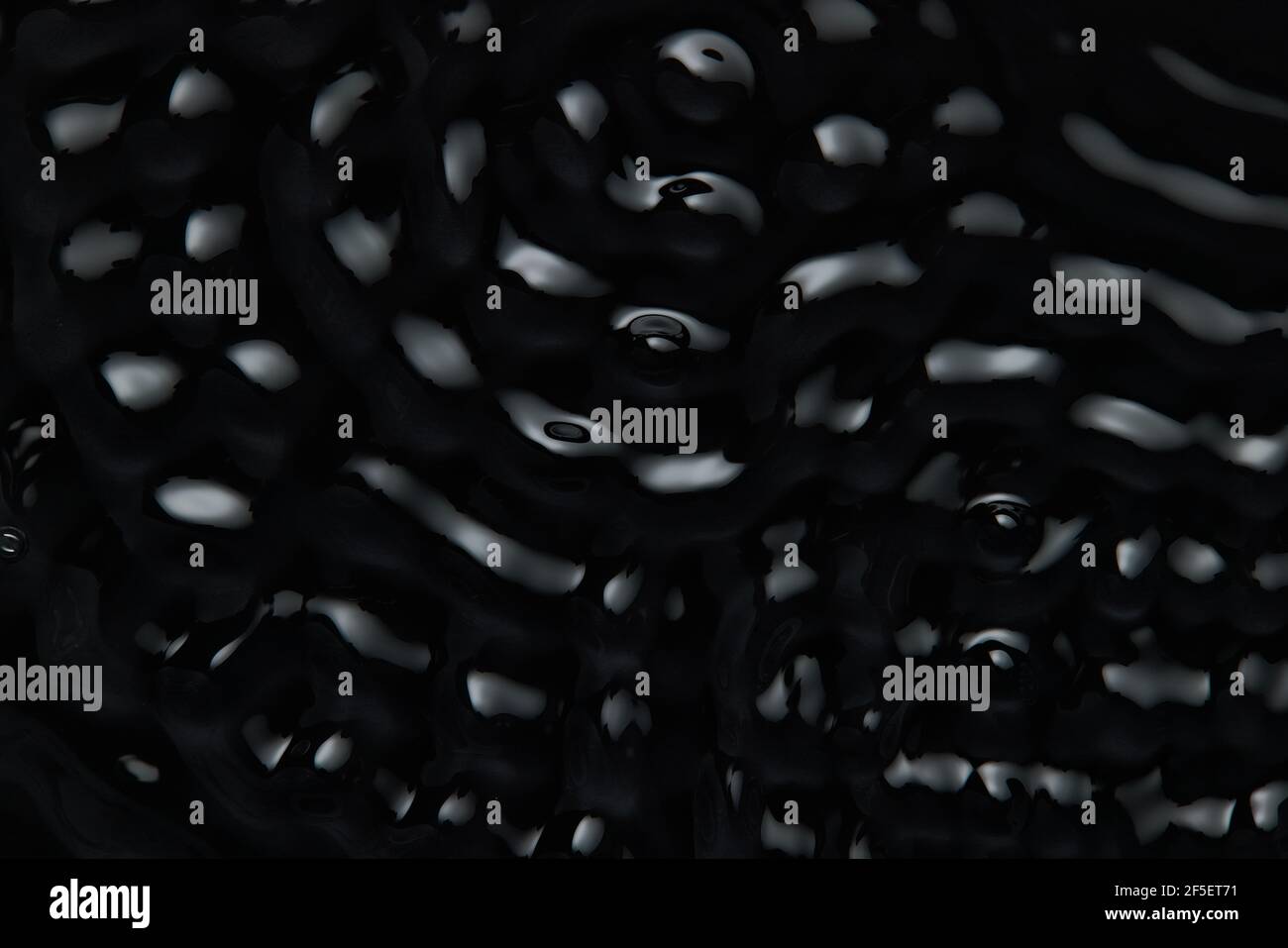 Splashes and drops on the surface of the liquid. Abstract Black ...