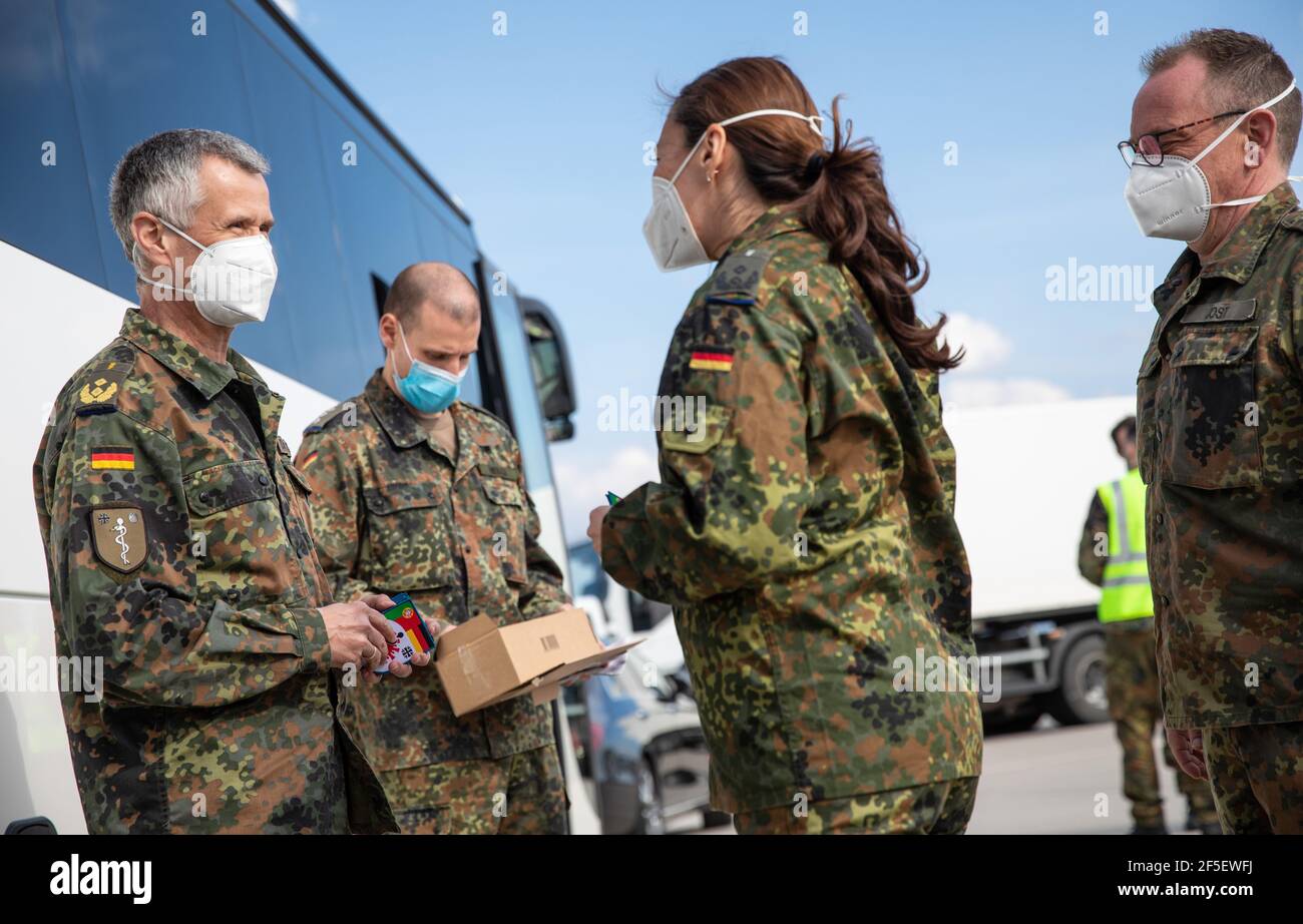 Stuttgart, Germany. 26th Mar, 2021. At Stuttgart airport, Surgeon General  Dr. Stefan Schmidt (l) welcomes Bundeswehr medical soldiers who have  returned from Portugal and gives them a special patch for their service.