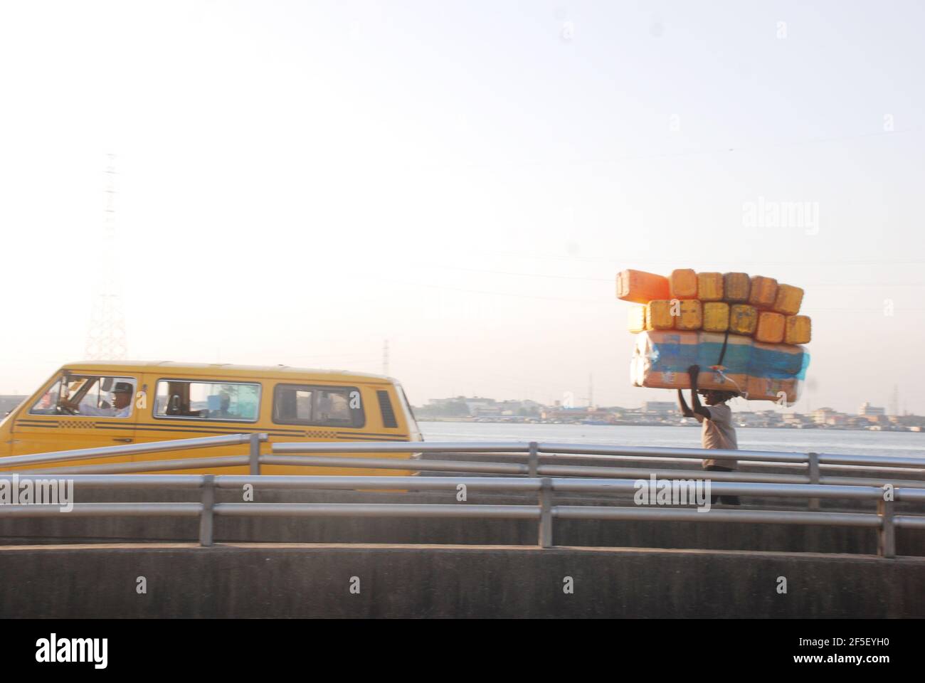 25. Lagos Metro: Man competing with the yellow bus driver in Lagos, Nigeria. Stock Photo