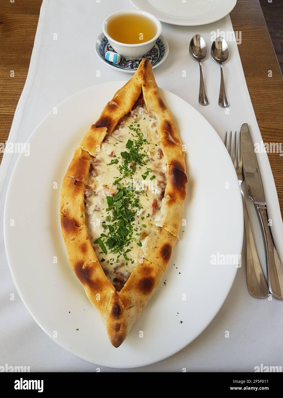 Traditional Turkish Cuisine Kasarli Pide boat-shaped flatbread with cheese, spices and herbs Food photography Stock Photo