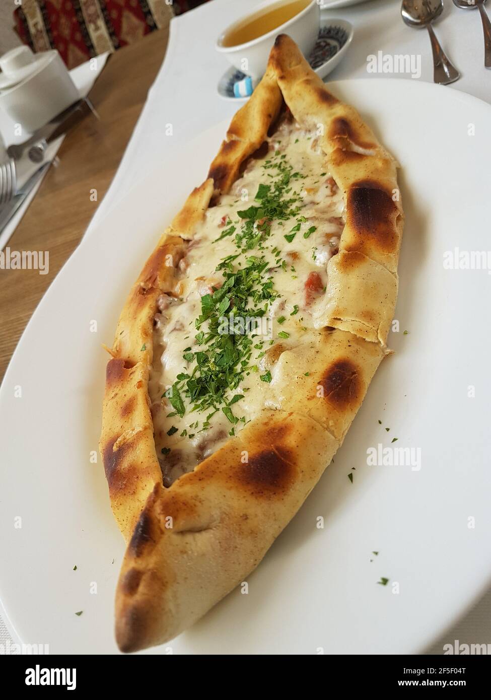 Traditional Turkish Cuisine Kasarli Pide boat-shaped flatbread with cheese, spices and herbs Food photography Stock Photo