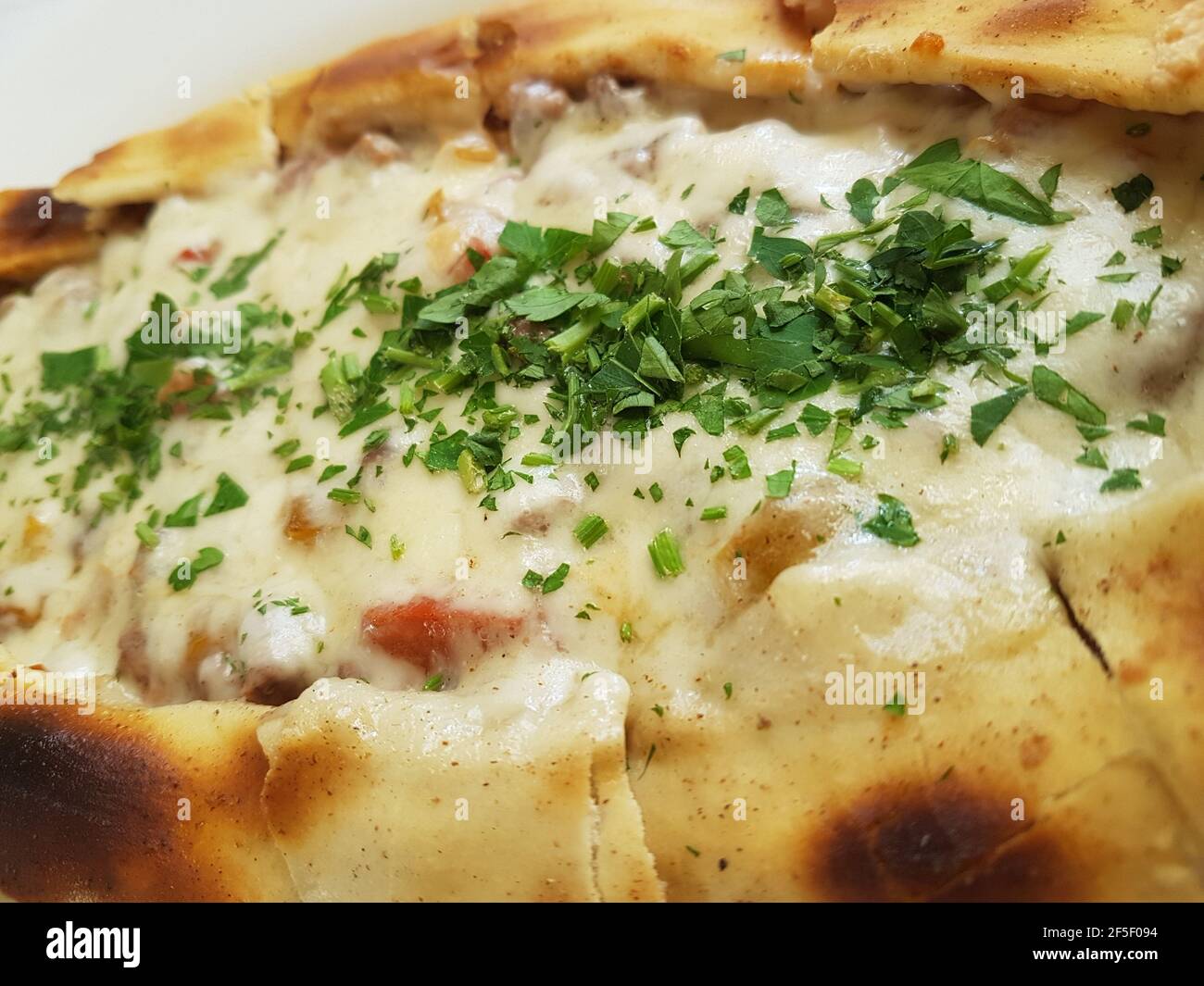 Traditional Turkish Cuisine Kasarli Pide boat-shaped flatbread with cheese, spices and herbs Food photography Stock Photo