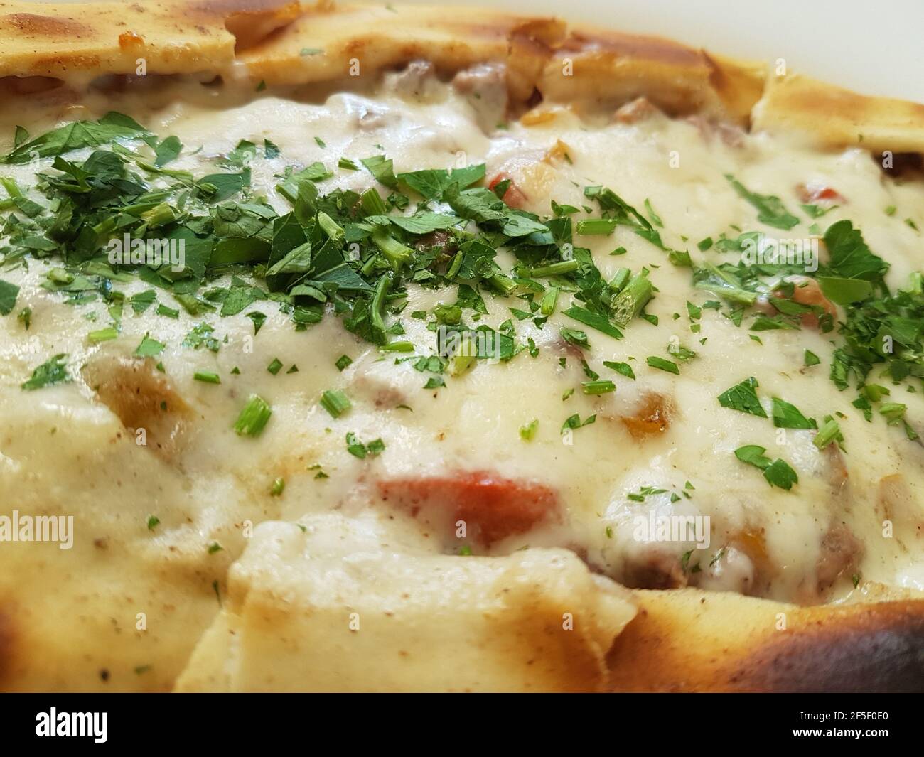 Traditional Turkish Cuisine Kasarli Pide boat-shaped flatbread with cheese, spices and herbs Food photography Stock Photo