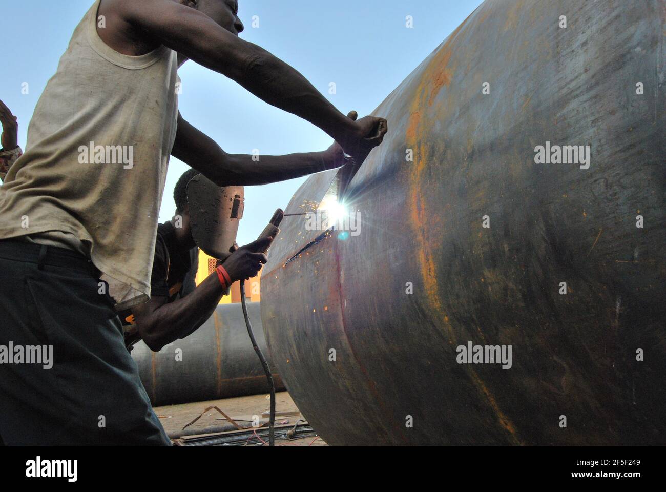 African welders constructing an Oil tank in Lagos Nigeria Stock Photo