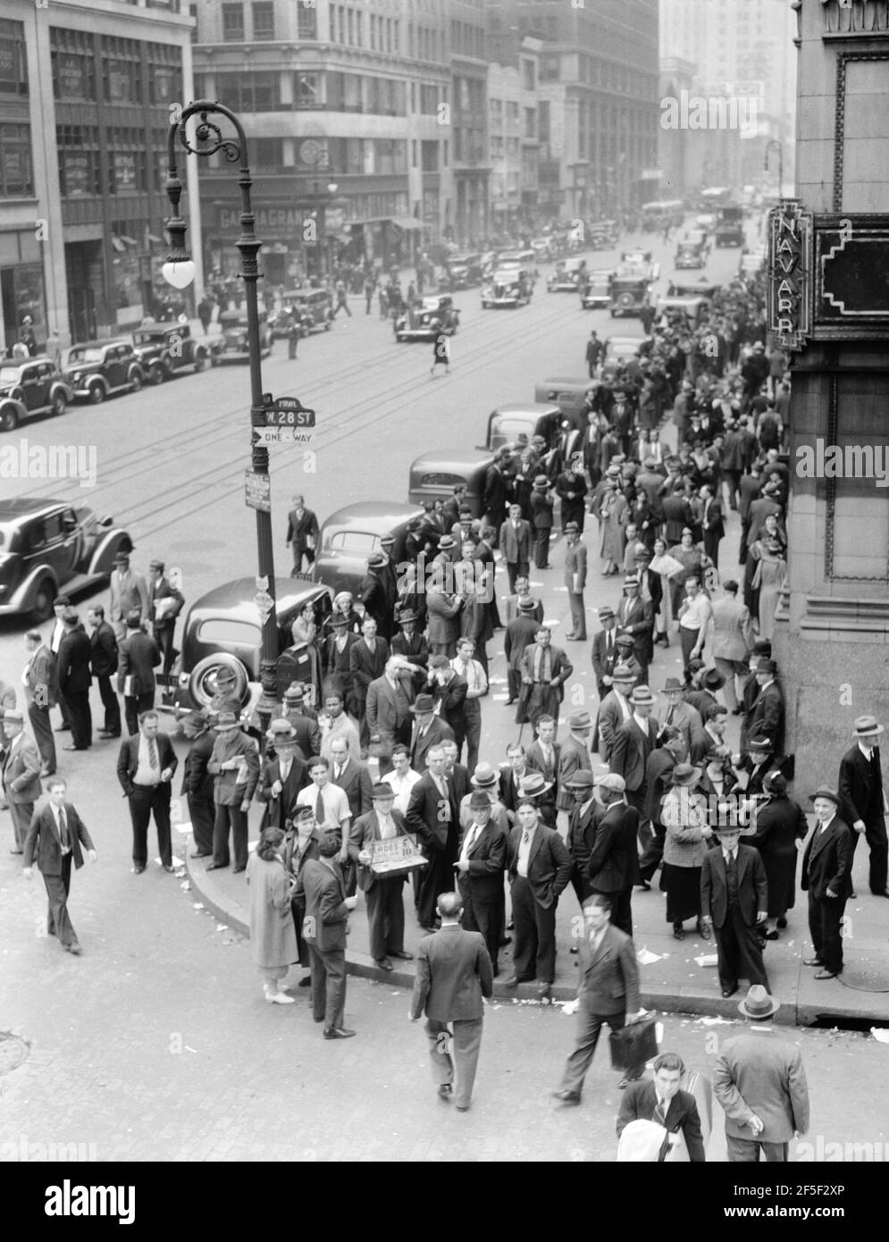 Background for Hightstown project photographs. Seventh Avenue and West 28th Street, New York. Garment workers leave the factories for noon hour. June 1936. Photograph by Dorothea Lange. Stock Photo