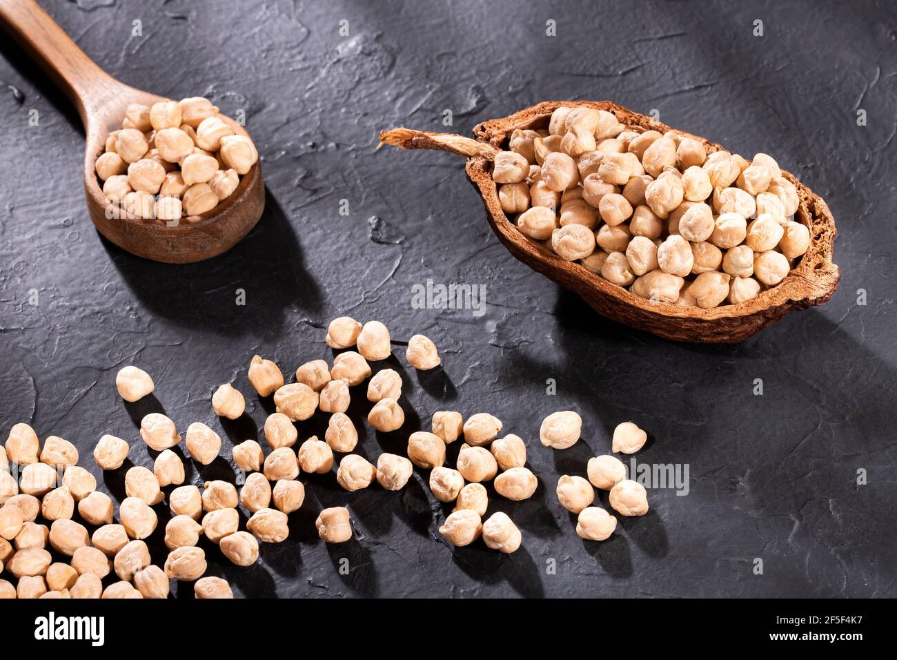 Raw chickpeas in the wooden bowl - Cicer arietinum Stock Photo