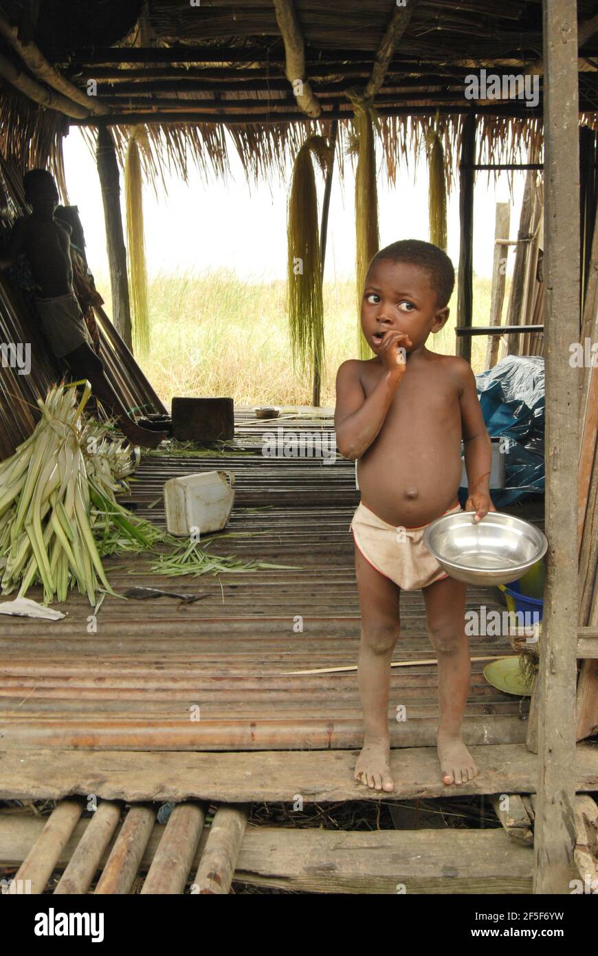 A boy standing in front of a house in Ondo State, Nigeria. Stock Photo