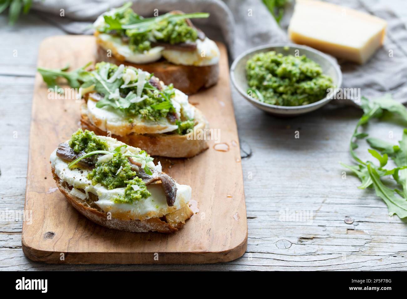 Crostini with mozzarella, anchovies and rocket pesto Stock Photo Alamy