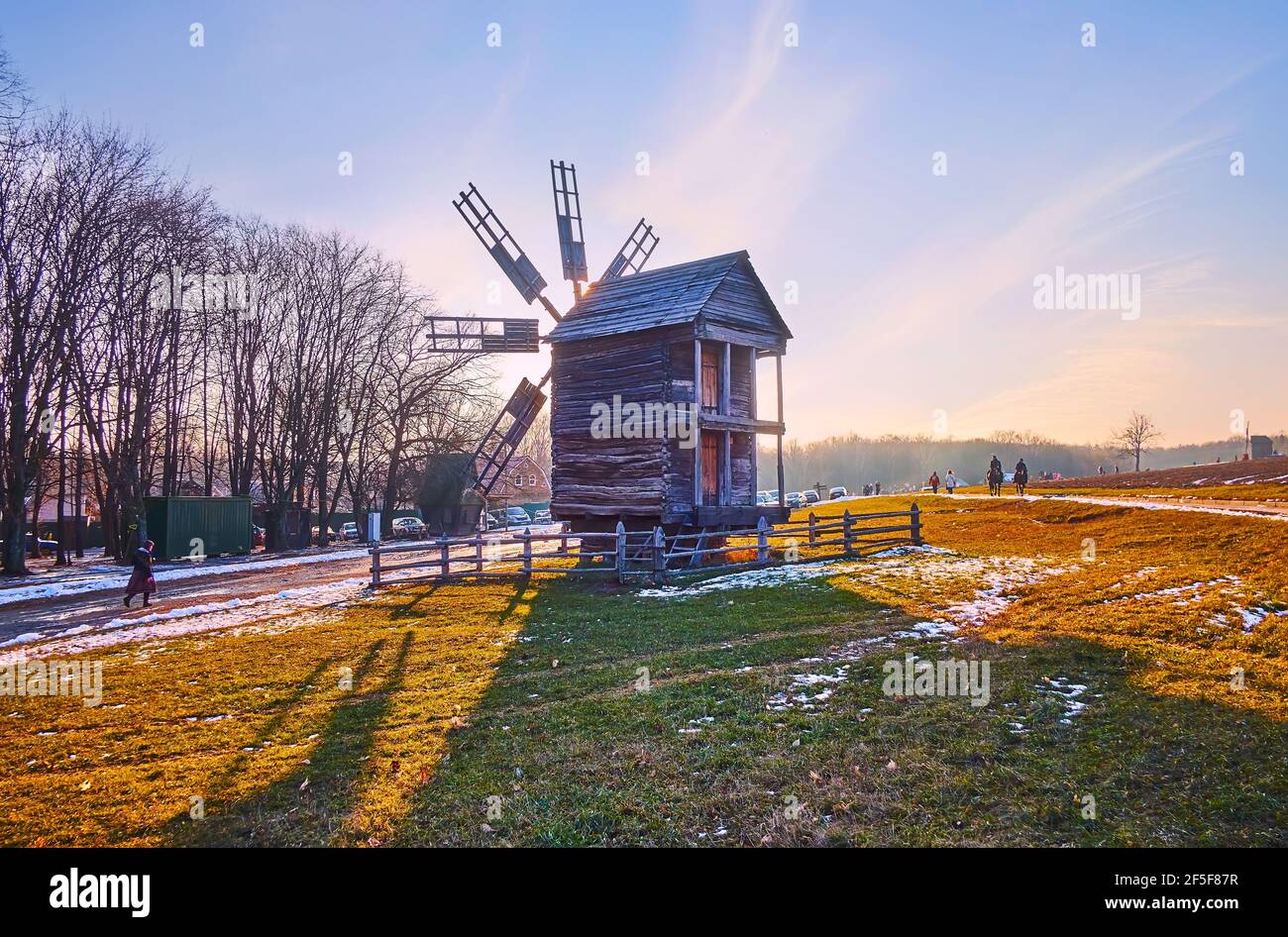 The evening sun is seen through the sails of the old timber windmill, Pyrohiv Skansen, Kyiv, Ukraine Stock Photo