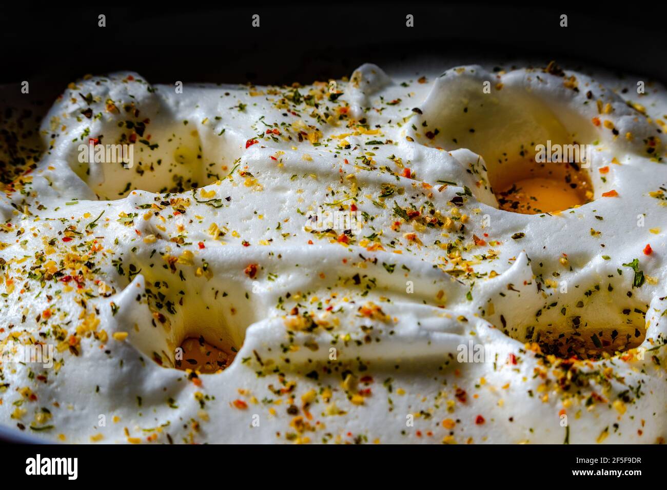 Bitten egg white with the hole eggs inside, ready to cook in the oven