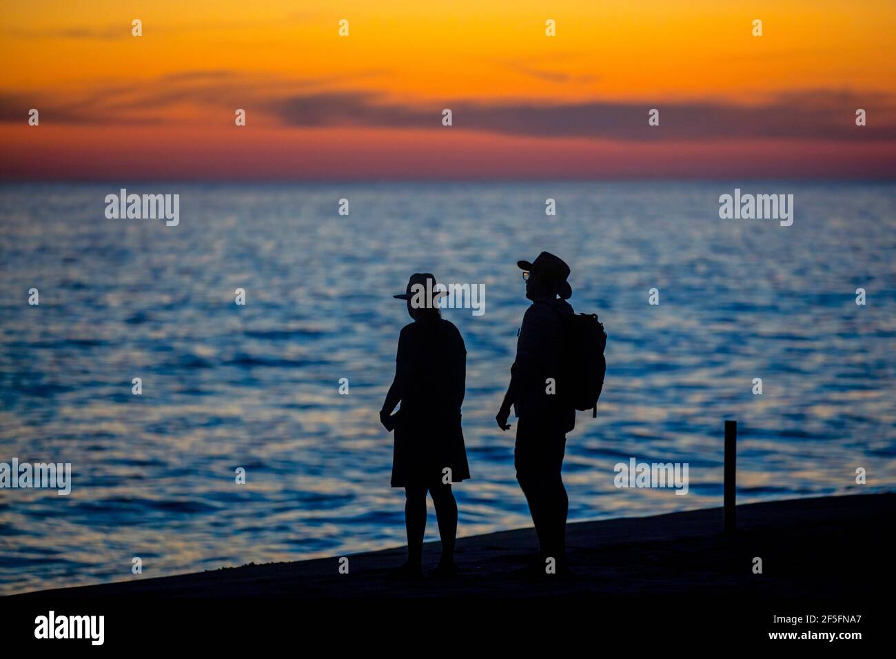 Silhouette of Mexican couple watching the sunset over the North Pacific Ocean from beach near Puerto Escondido, San Pedro Mixtepec, Oaxaca, Mexico Stock Photo