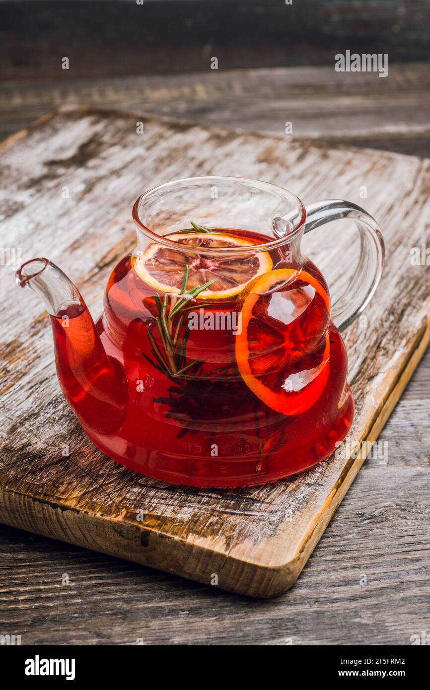 Fruit drink based on raspberry with red orange slice in glass teapot ...