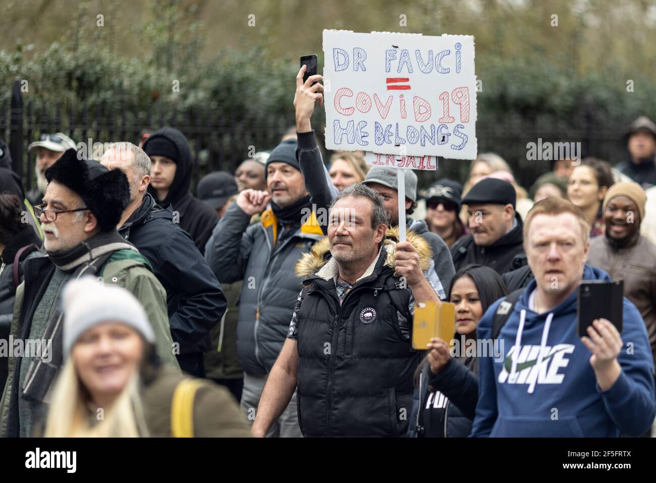 Anti-lockdown and anti Covid-19 vaccination protest, Hyde Park, London, 20 March 2021. Marching protesters and a placard. Stock Photo
