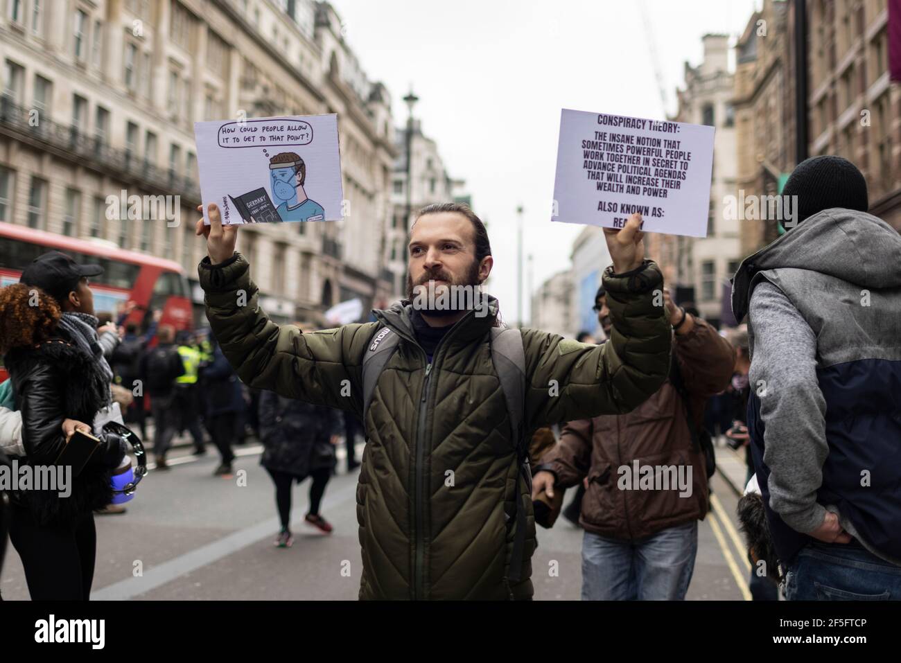 Anti-lockdown and anti Covid-19 vaccination protest, London, 20 March 2021. Protester with two placards. Stock Photo