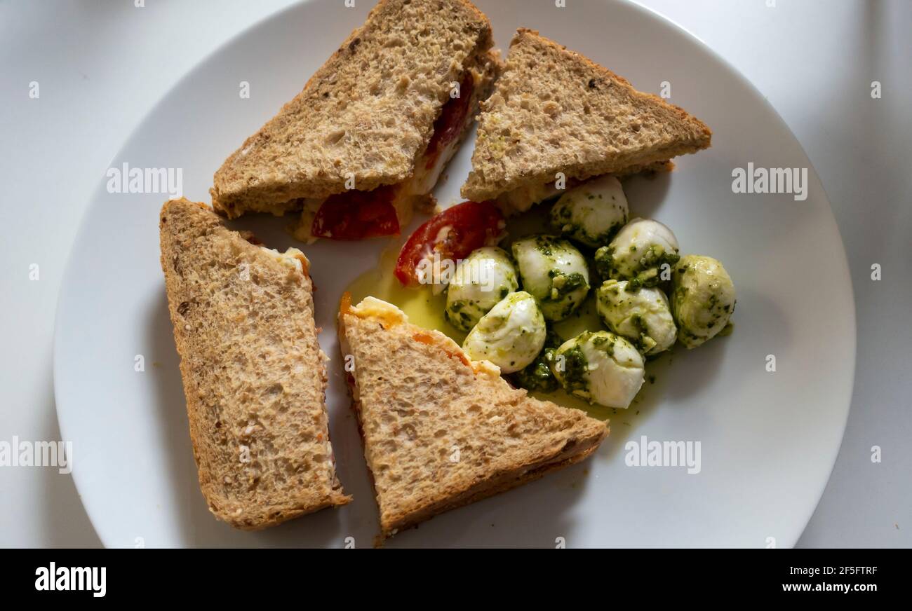 Egg and tomato sandwich on brown bread and mozzarella ball in oil and