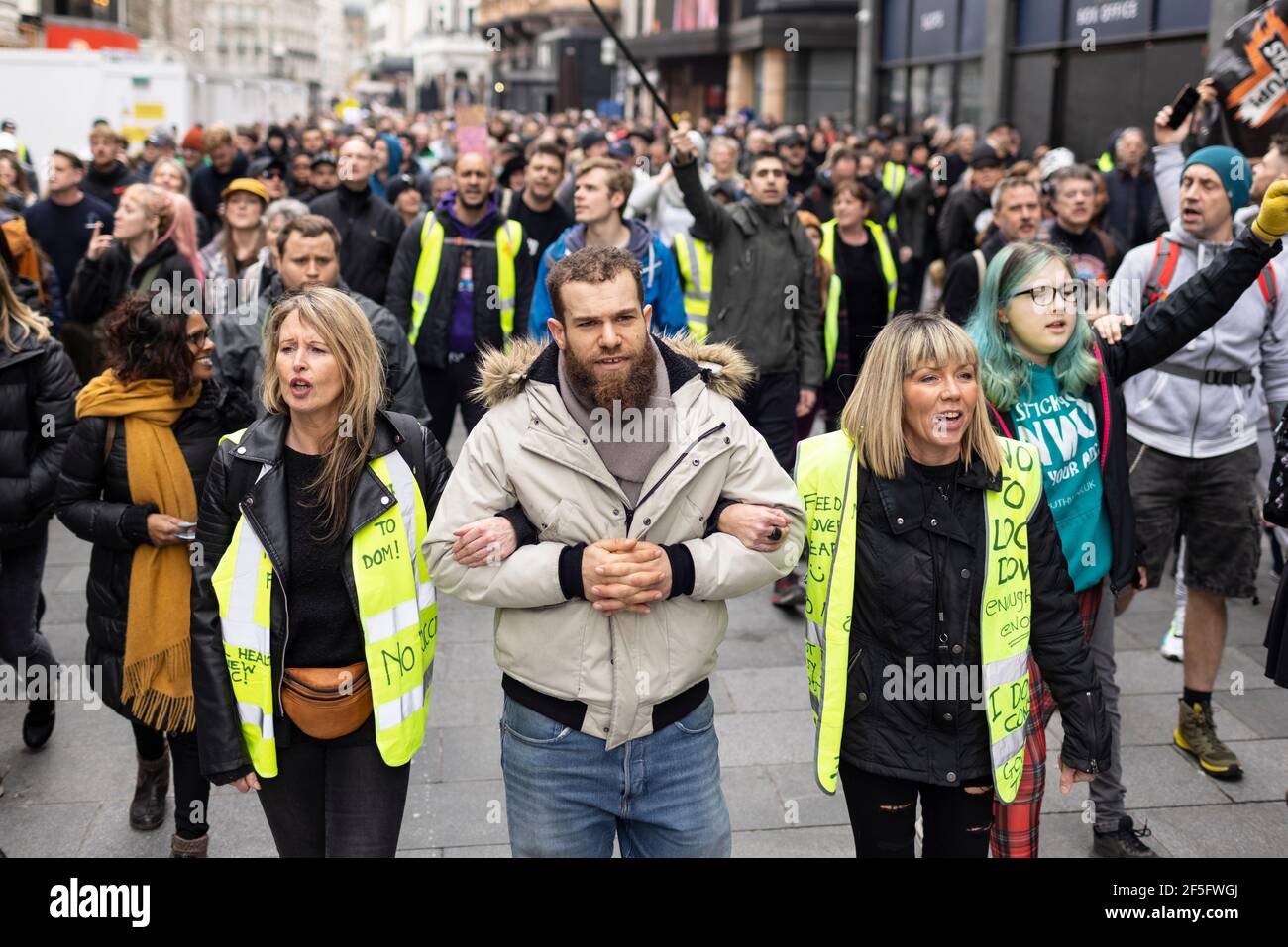 Anti-lockdown and anti Covid-19 vaccination protest, London, 20 March 2021. Protesters marching and locking arms. Stock Photo