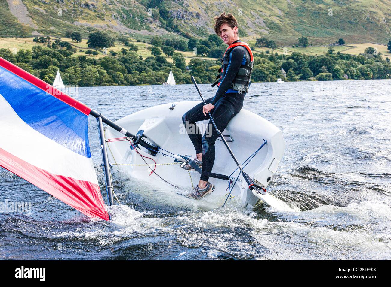 The English Lake District - Sailing on Ullswater, Cumbria UK - A young man in the process of capsizing a dinghy Stock Photo