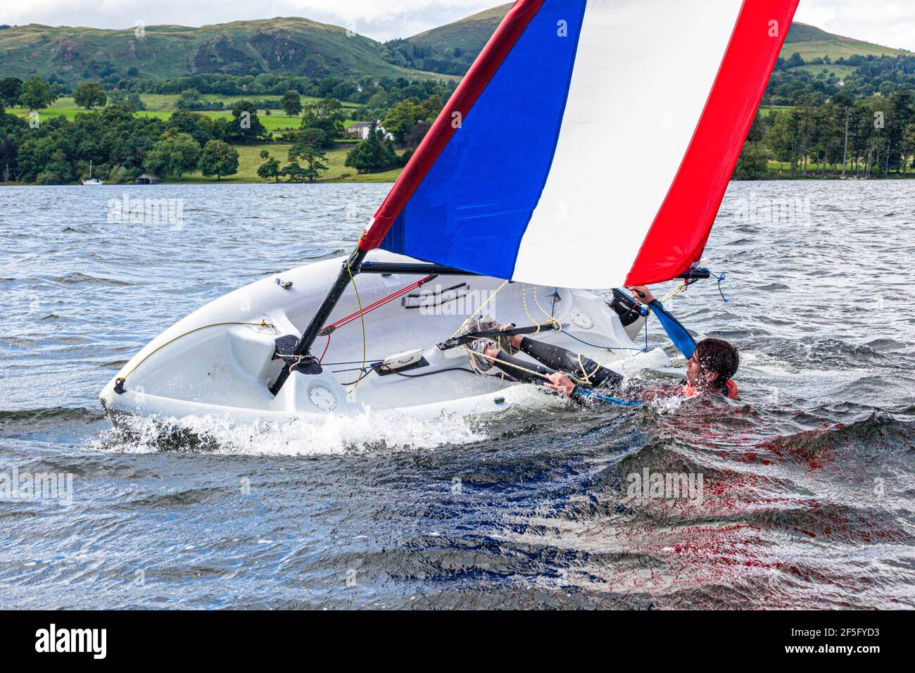 The English Lake District - Sailing on Ullswater, Cumbria UK - A young man capsizing a dinghy Stock Photo