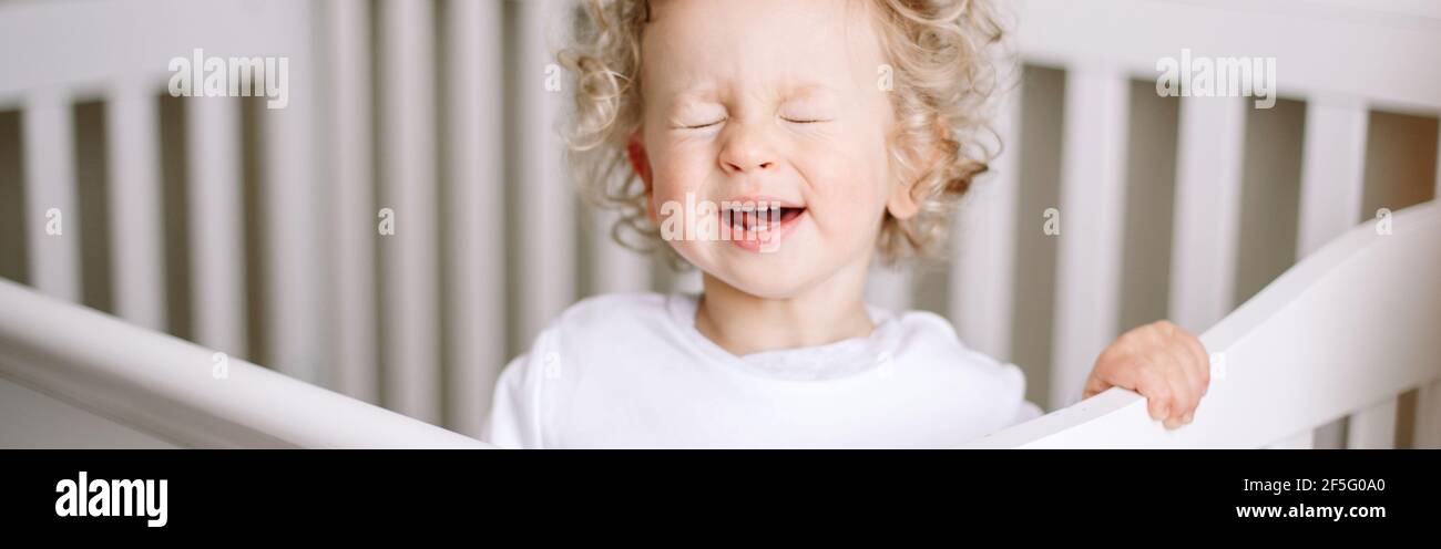 Kid tantrum. Baby boy crying in crib at kids nursery room at home. Funny baby boy with curly blond hair screaming at bed. Terrible two toddler Stock Photo - Alamy Kid tantrum. Baby boy crying in crib at kids nursery room at home. Funny baby boy with curly blond hair screaming at bed. Terrible two toddler Stock Photo - Alamy