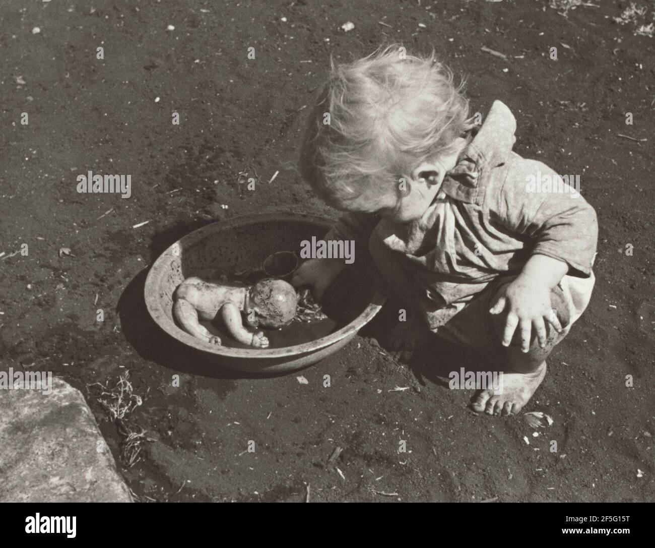 A Child of Migratory Packing House Workers Washing Her Doll, Belle