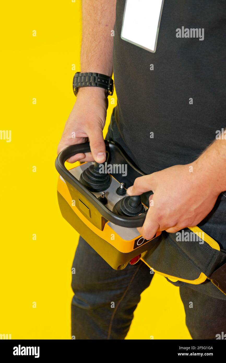 Worker Holding Remote Control With Joysticks for Construction Machinery Stock Photo