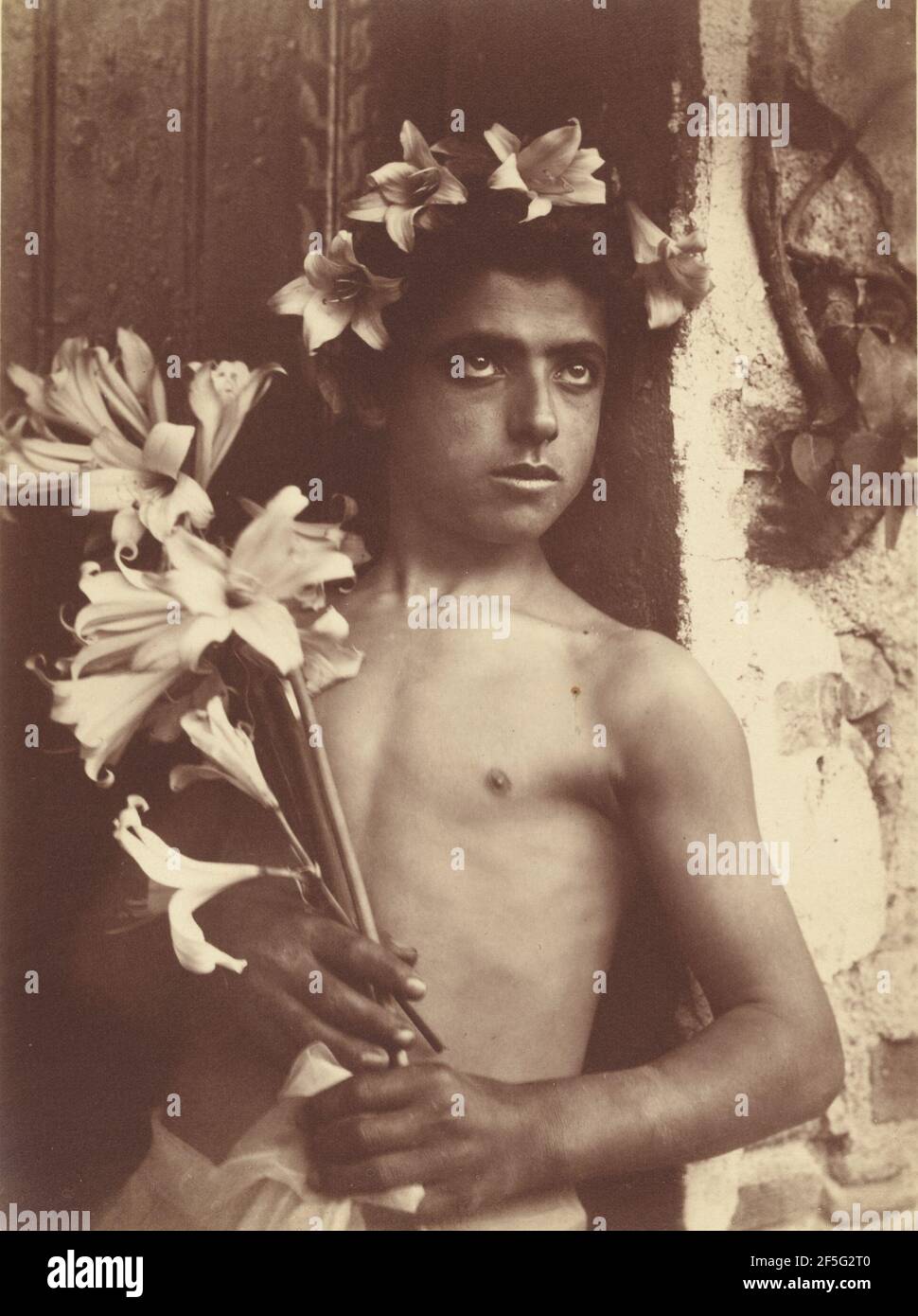 Boy with lillies. Baron Wilhelm von Gloeden (German, 1856 - 1931) Stock Photo