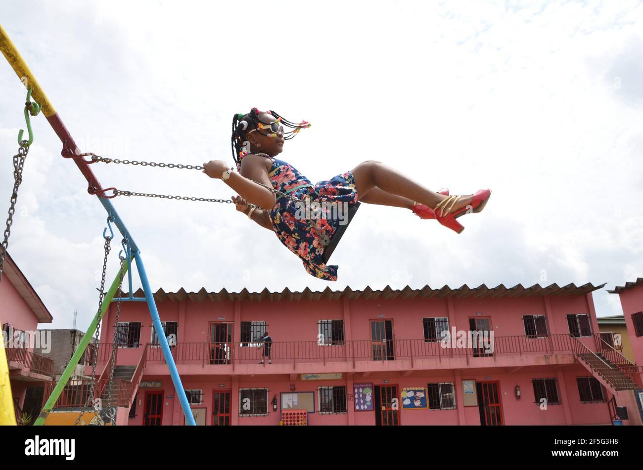 An African girl swinging in the school premises, Lagos, Nigeria. Stock Photo