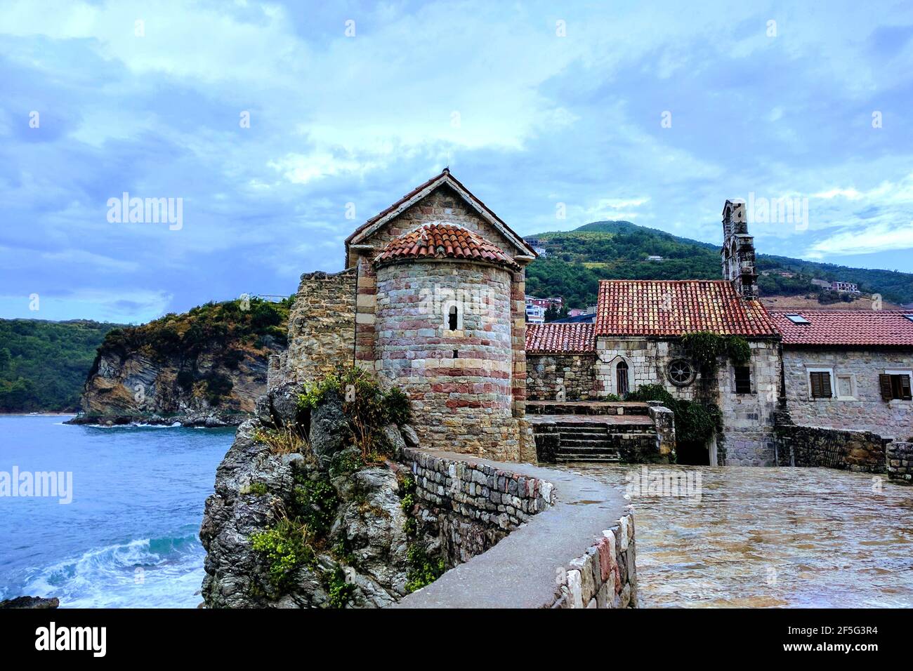 Old tower with a medieval wall on rock by the sea. Old Budva, Montenegro. Stock Photo