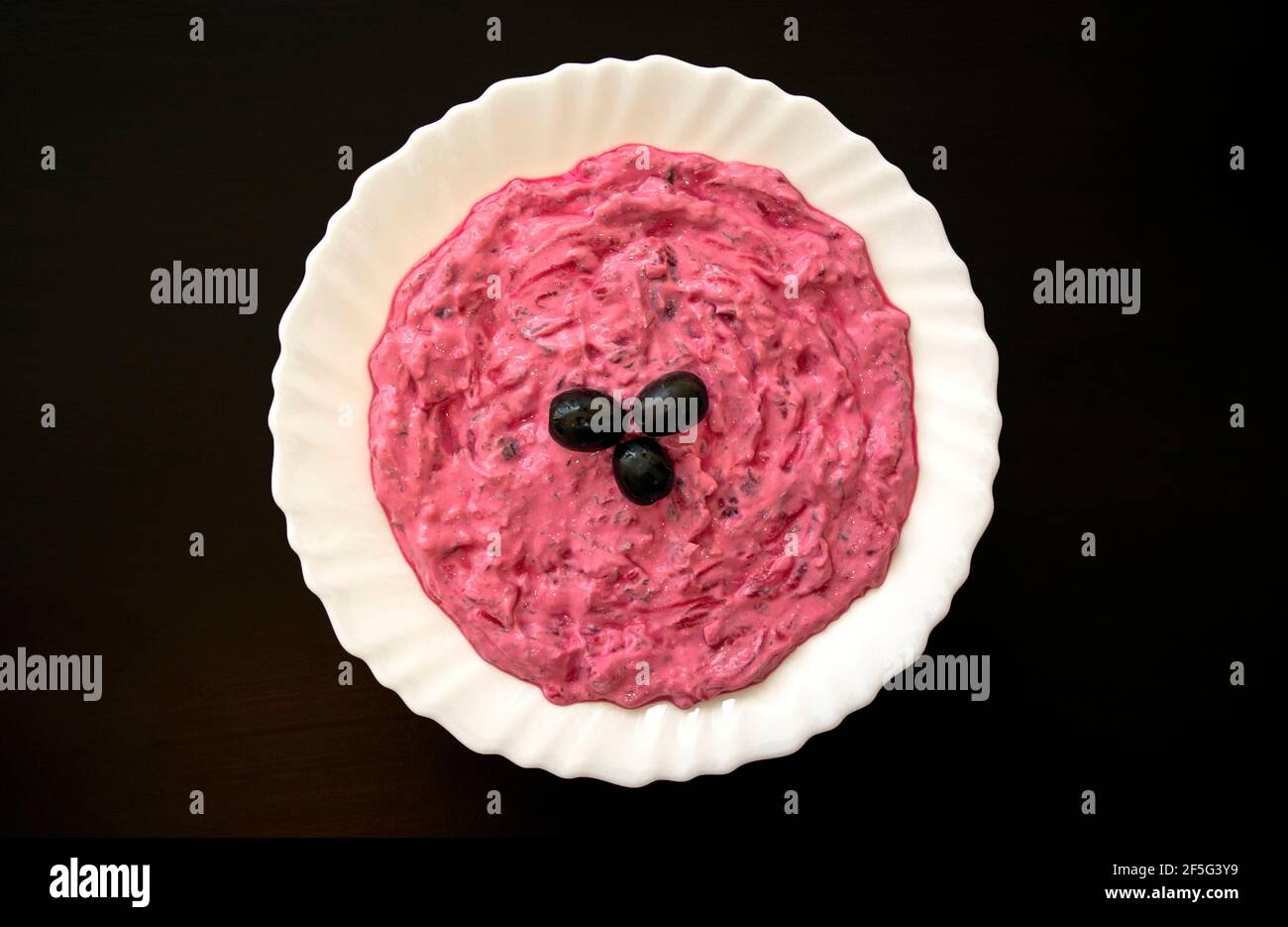 Famous traditional Arabic cuisine Beet hummus on a white plate on a